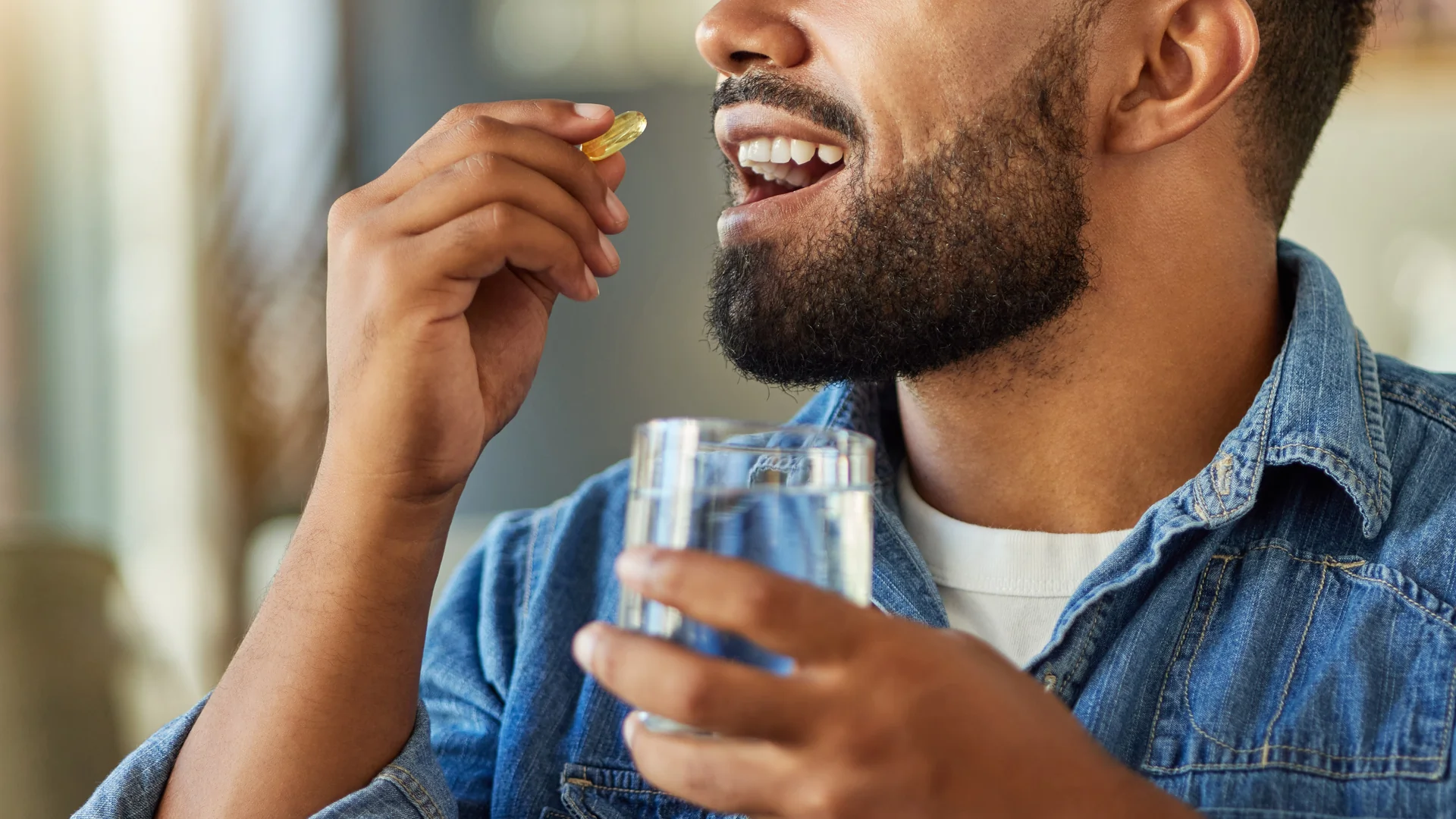Un homme prenant un complément alimentaire avec un verre d'eau pour soutenir sa santé cognitive