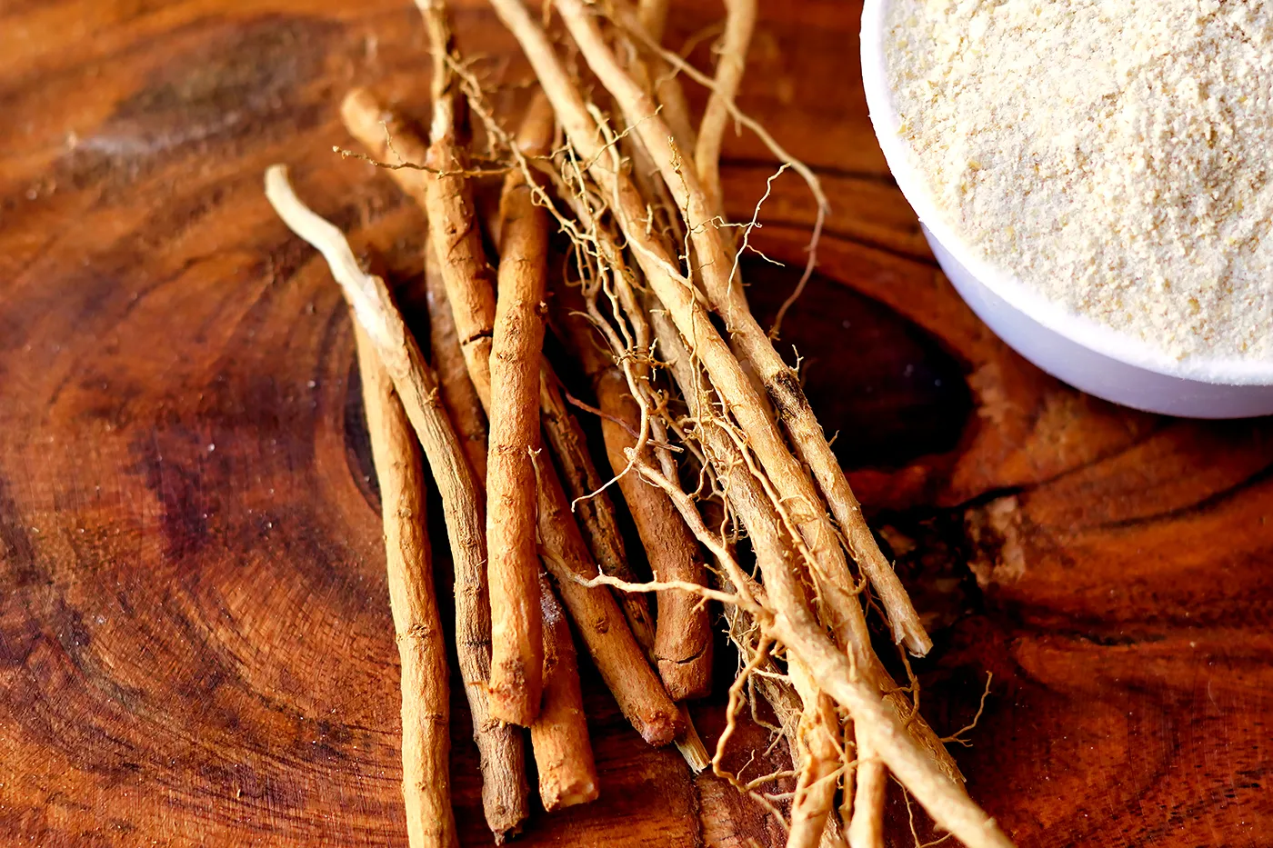 Racines d'ashwagandha et poudre dans un bol blanc