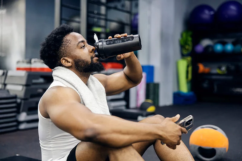 Shaker de protéines et compléments alimentaires sur une table de cuisine