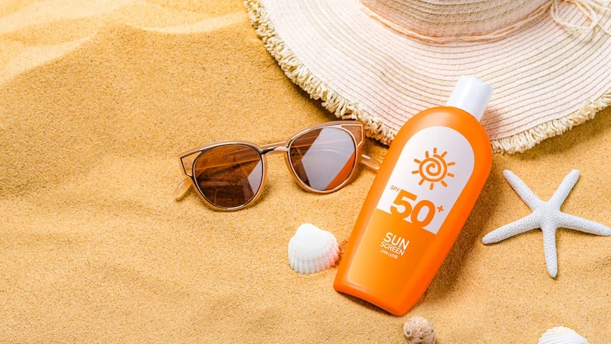 Crème solaire et chapeau de paille rappelant la nécessité d'une protection UV réelle