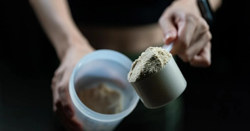 Divers compléments alimentaires de protéines en poudre avec un shaker et une dosette.