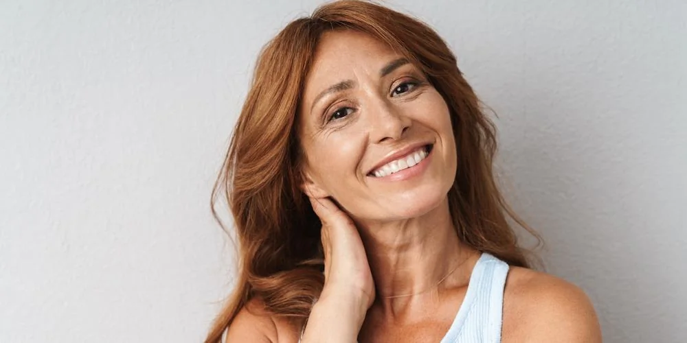 Femme mûre sereine en extérieur illustrant l'équilibre hormonal