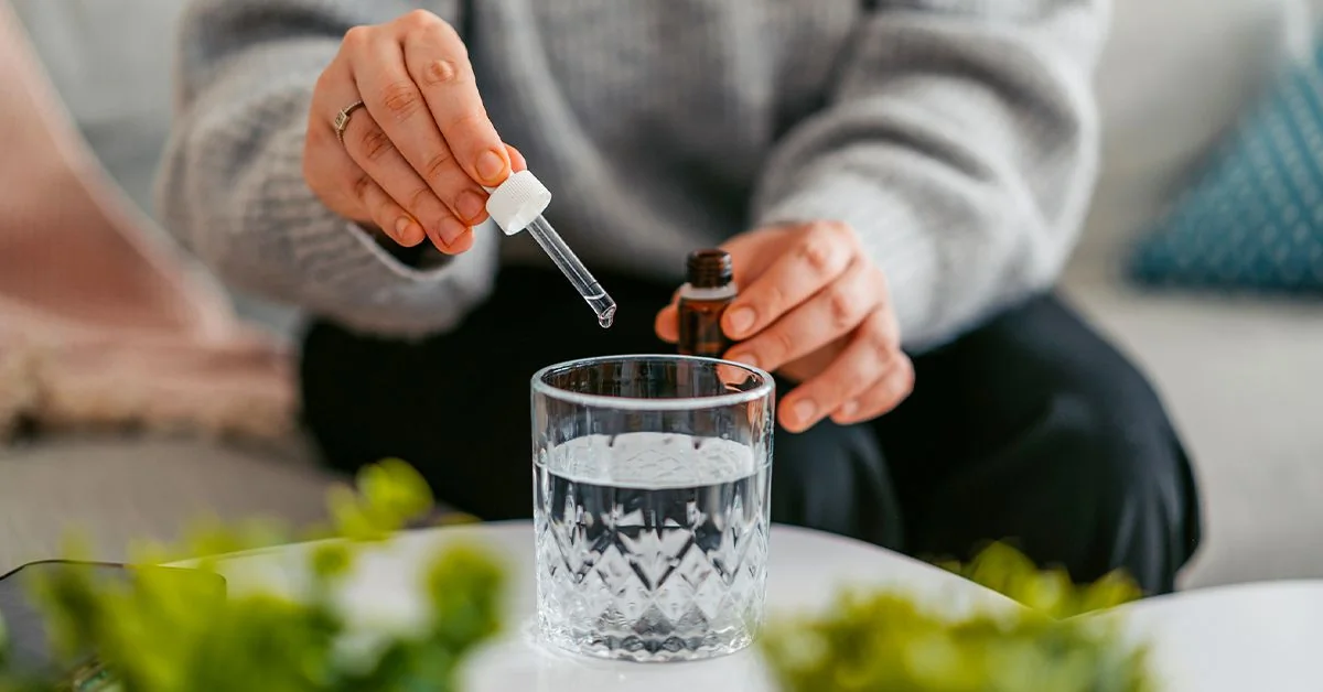 Flacon de gouttes d'acide fulvique et gélules de compléments alimentaires sur un plan de travail.