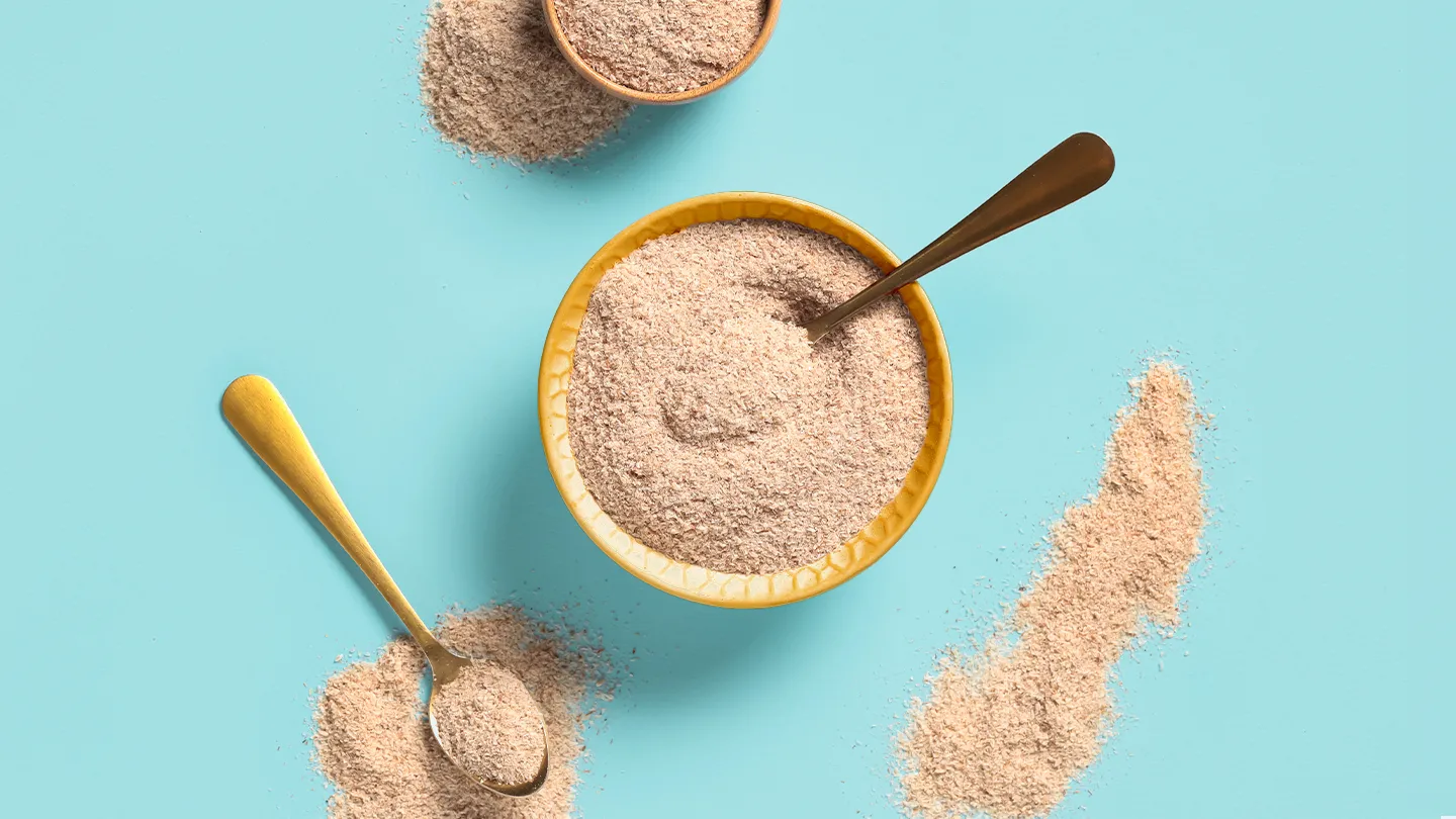 Flacons de médicaments et verre d'eau illustrant les interactions avec le psyllium