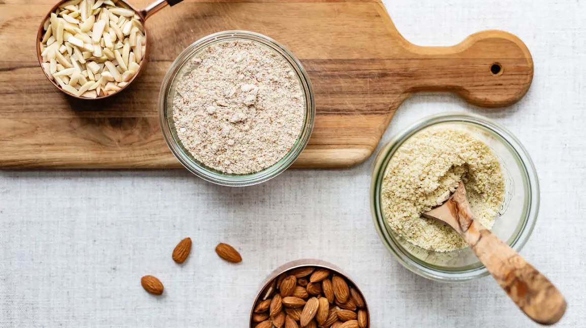 Amandes et farine d'amande sur une planche à découper
