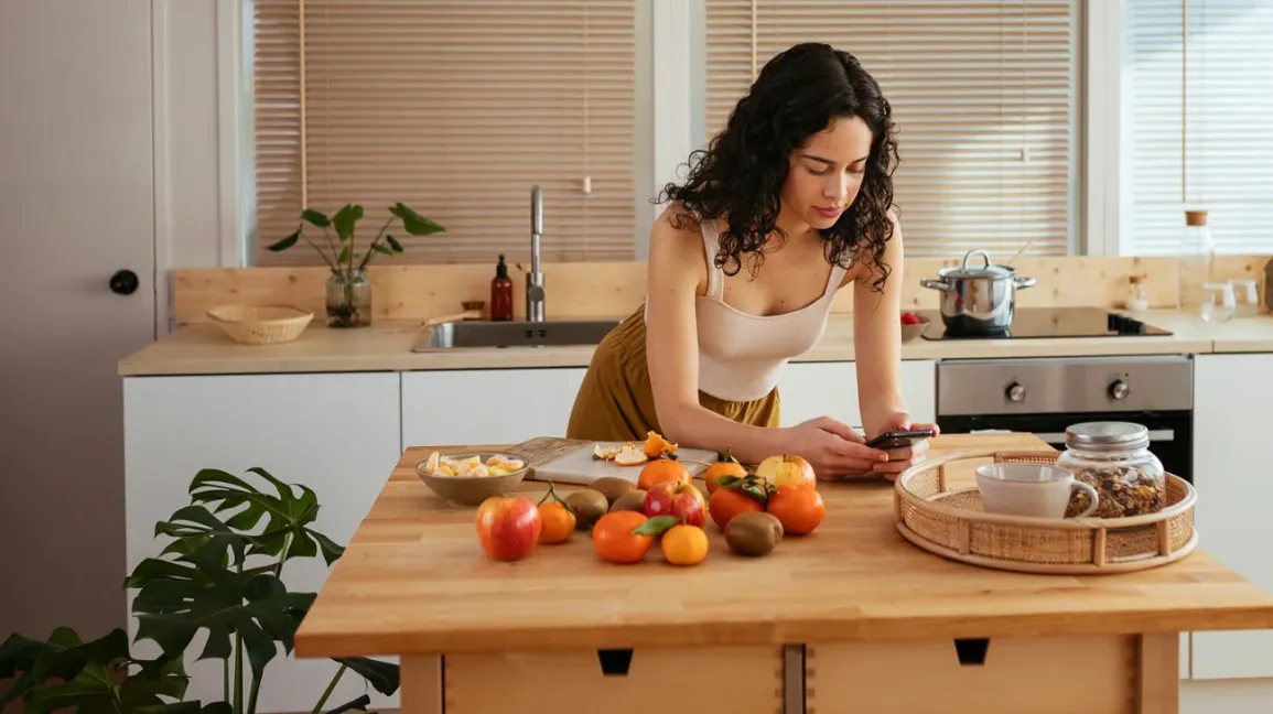 Femme consultant son téléphone dans une cuisine
