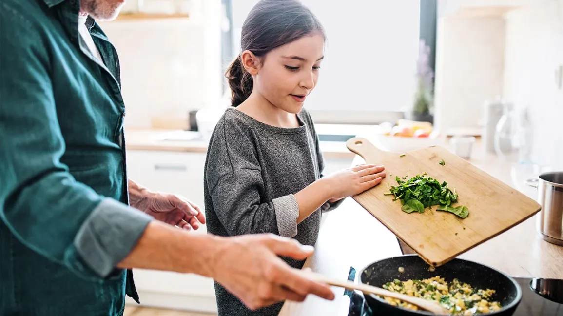 Enfant préparant des œufs en cuisine
