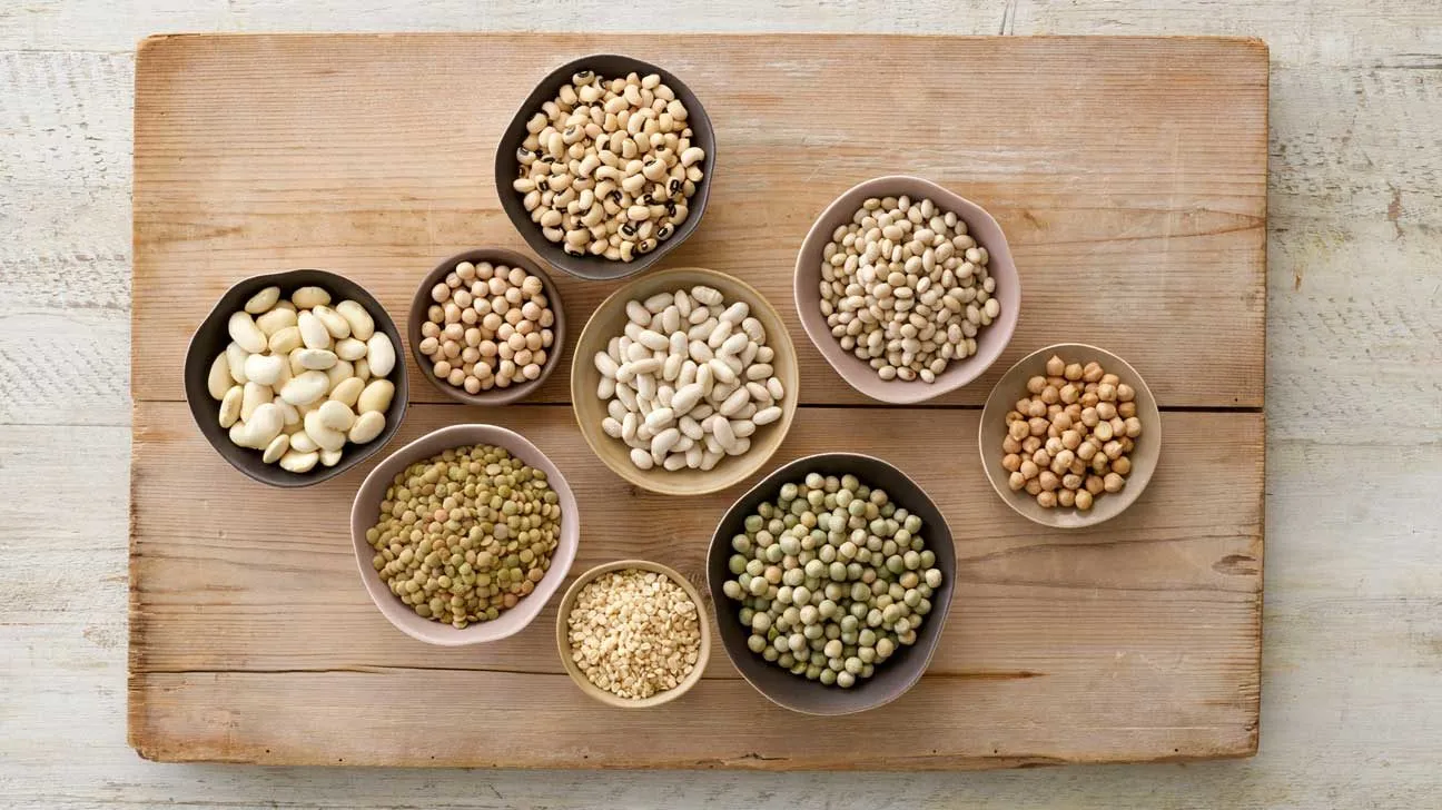 bols de diverses légumineuses sur une planche à découper