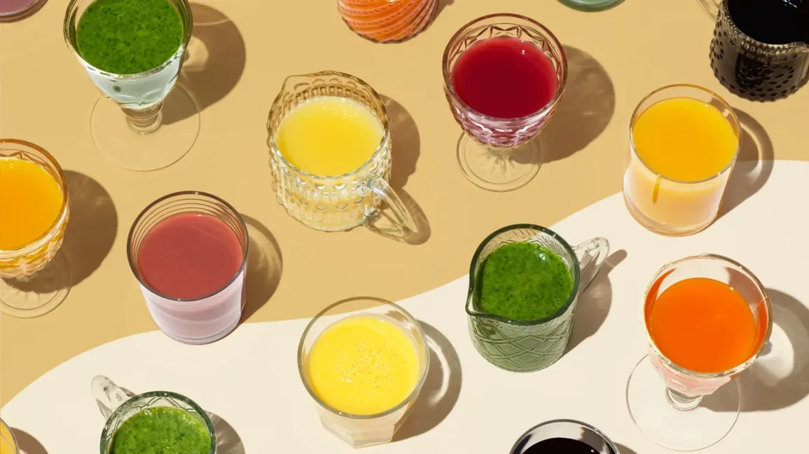 Assortiment de verres de jus de fruits et légumes colorés