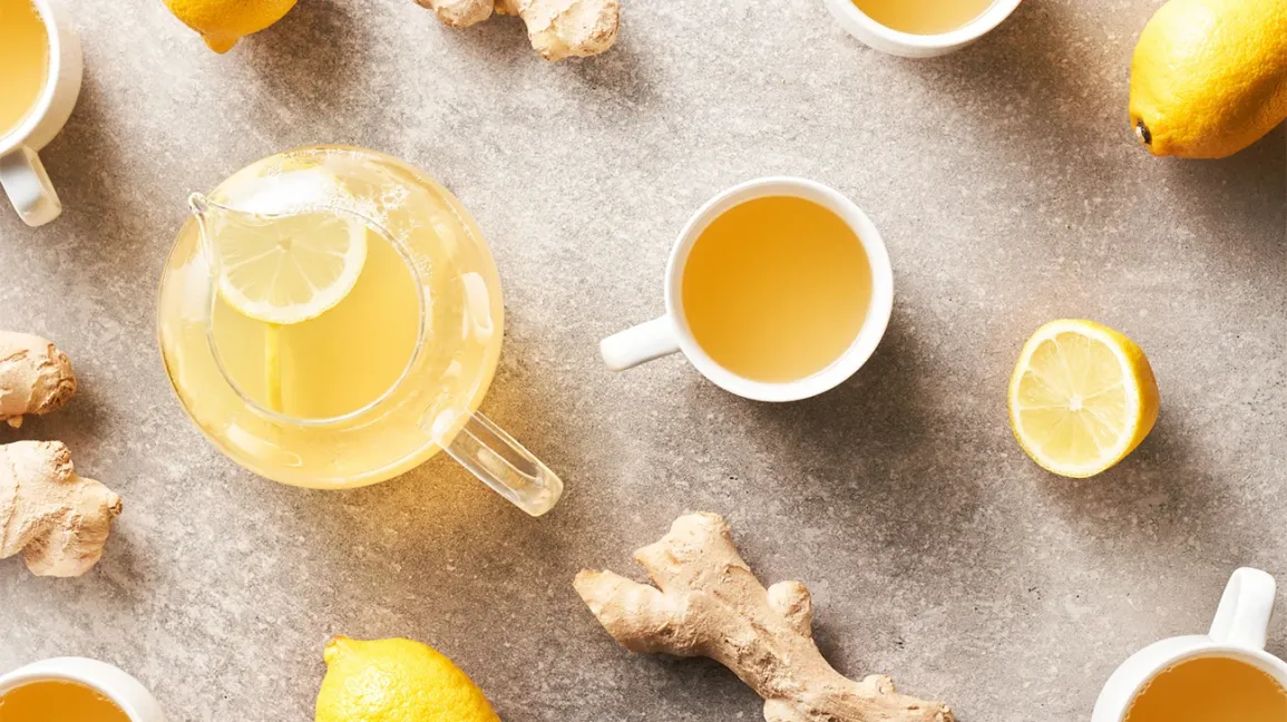 Une tasse d'infusion citron gingembre fumante sur une table en bois
