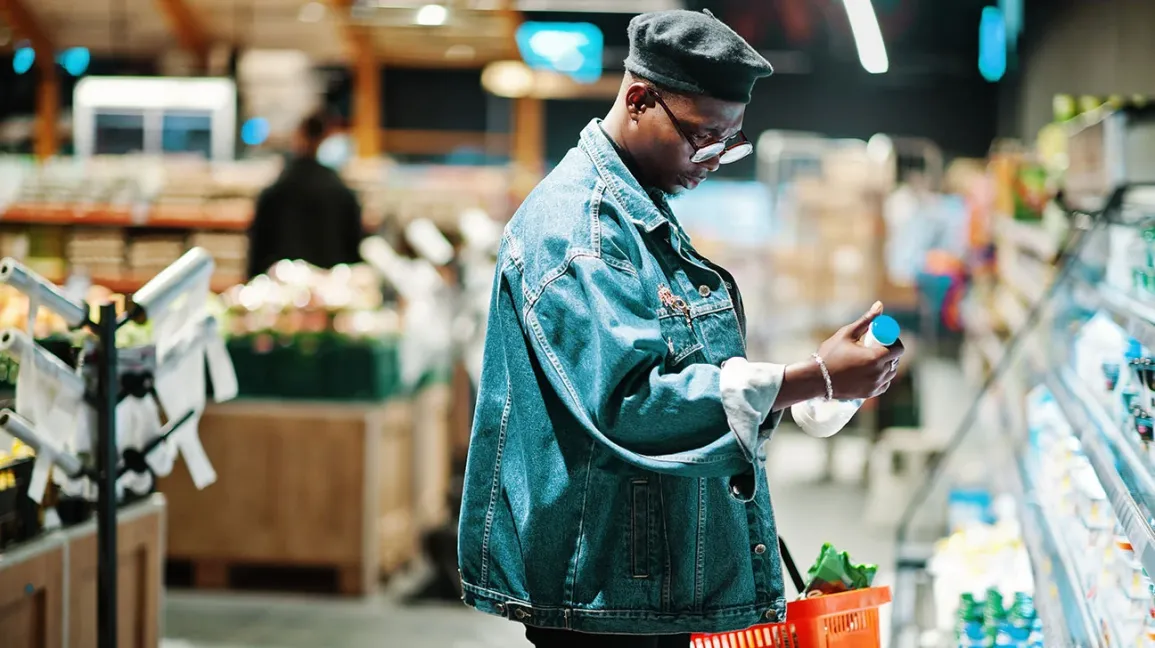 Un consommateur examine l'étiquette d'une bouteille de lait pasteurisé