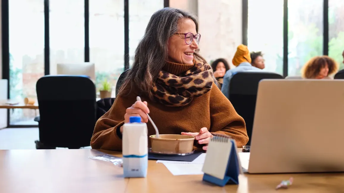 Femme mangeant des restes sains pour son déjeuner au bureau