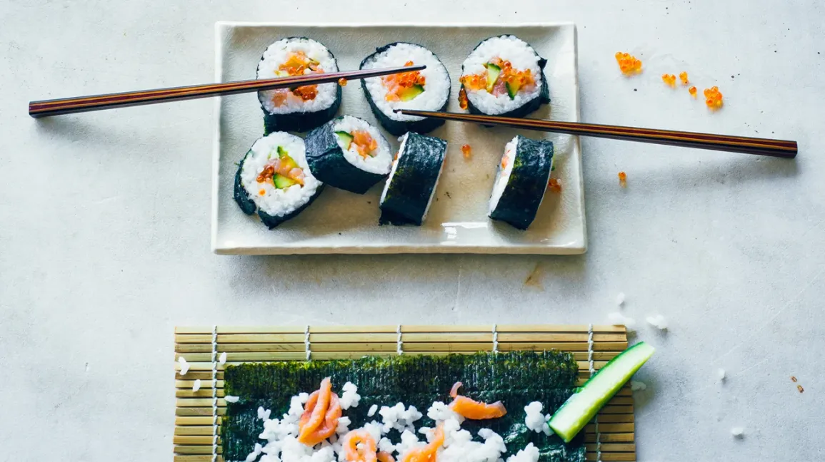 Sushis faits maison sur un comptoir avec divers ingrédients