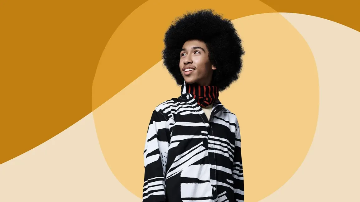 Tabay Atkins, chef végétalien posant devant un fond géométrique jaune