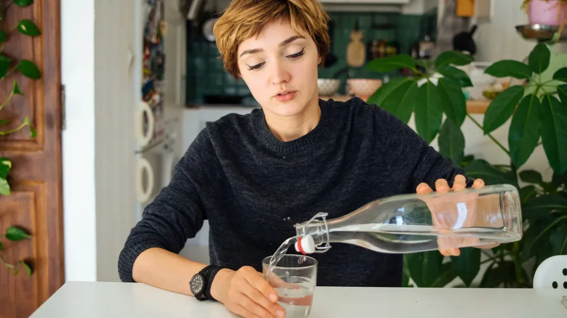 femme versant de l'eau dans un verre