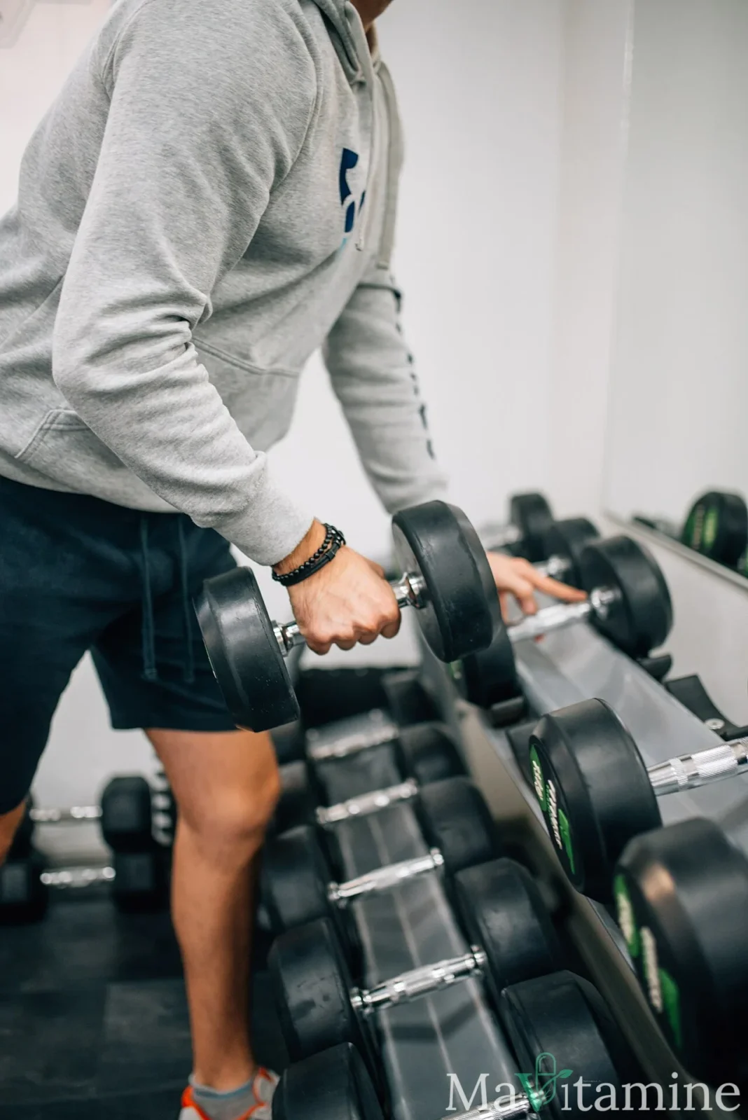 Sportif effectuant un exercice avec haltère dans une salle de musculation